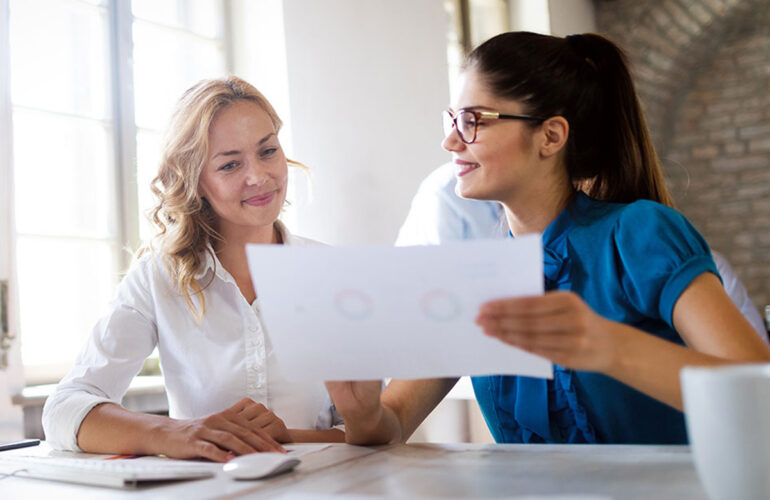 A photo of a hiring manager reviewing resumes and conducting interviews.